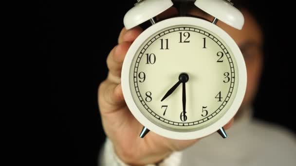 Half acht oclock. Menselijke hand met wekker die zevenendertig oclock en rinkelend laat zien. — Stockvideo