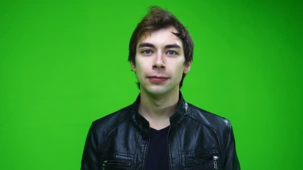 Retrato de homem branco em jaqueta de couro olhando para a câmera na tela verde. — Vídeo de Stock