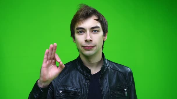 緑の画面の背景に承認またはOKサインを示す革のジャケットの白い男. — ストック動画