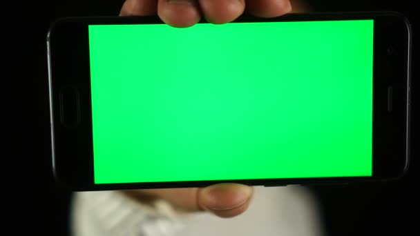 Неузнаваемый человек показывает смартфон с хрома-ключом, зеленый экран — стоковое видео