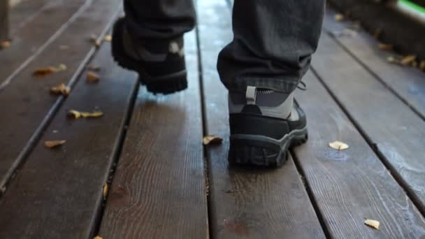 Homem está andando no chão de madeira, no terraço durante o dia no outono — Vídeo de Stock