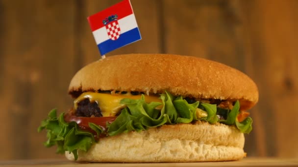 Deliciosa hamburguesa con pequeña bandera croata encima de ellos con palillos de dientes. Deliciosa hamburguesa giratoria. — Vídeo de stock