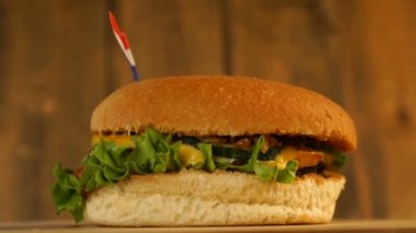 Üstünde kürdanla küçük Hollanda bayrağı olan lezzetli bir burger. Lezzetli hamburger dönüyor..