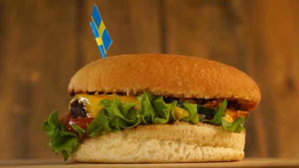 Delicioso hambúrguer com pequena bandeira sueca em cima deles com palitos. Hambúrguer delicioso rotativo. — Vídeo de Stock