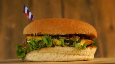 Üstünde kürdanla küçük Küba bayrağı olan leziz bir burger. Lezzetli hamburger dönüyor..