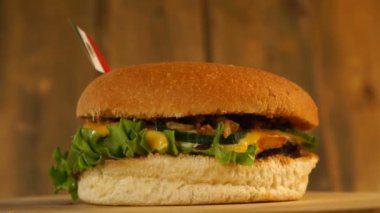 Üstünde küçük Meksika bayrağı olan leziz bir hamburger ve kürdan. Lezzetli hamburger dönüyor..