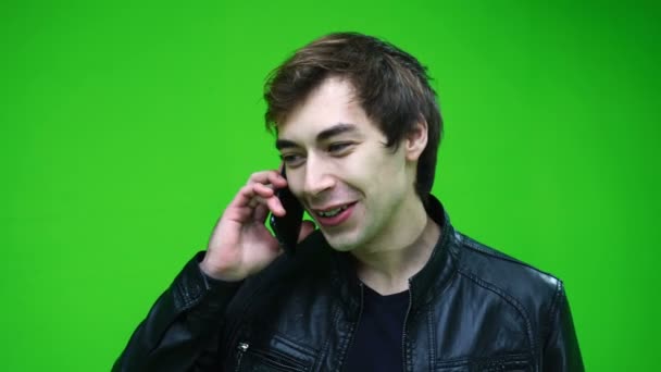 가죽 자켓을 입은 백인이 녹색 화면을 통해 전화로 이야기하는 모습. — 비디오