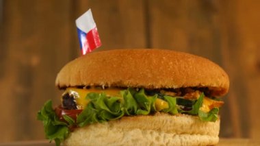 Üstünde kürdanla küçük Çek bayrağı olan leziz bir burger. Lezzetli hamburger dönüyor..