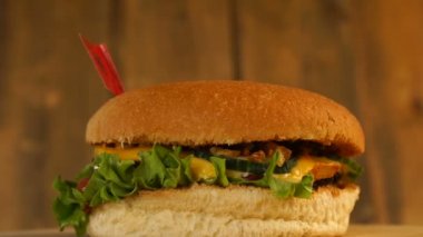 Üstünde küçük Arnavut bayrağı olan leziz bir hamburger ve kürdan. Lezzetli hamburger dönüyor..
