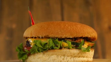 Üstünde kürdanla küçük Gine bayrağı olan lezzetli bir burger. Lezzetli hamburger dönüyor..