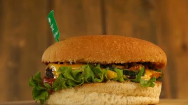 Üstünde kürdanla Suudi Arabistan bayrağı olan lezzetli bir burger. Lezzetli hamburger dönüyor..