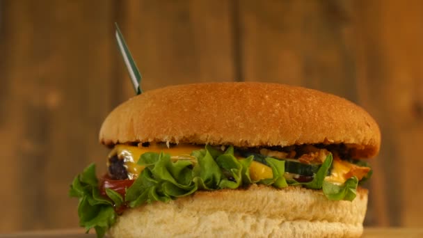 Burger lezat dengan bendera Nigeria kecil di atasnya dengan tusuk gigi. Hamburger Yummy berputar. — Stok Video