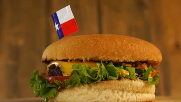 Delicioso hambúrguer com pequena bandeira do Texas em cima deles com palitos. Hambúrguer delicioso rotativo. — Vídeo de Stock