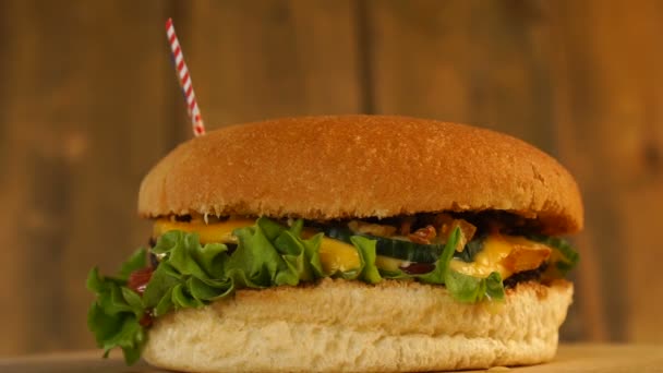 Deliciosa hamburguesa con bandera malaya pequeña encima de ellos con palillos de dientes. Deliciosa hamburguesa giratoria. — Vídeo de stock