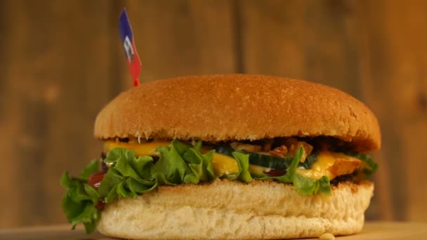 Deliciosa hamburguesa con pequeña bandera argentina encima con palillos de dientes. Deliciosa hamburguesa giratoria. — Vídeos de Stock