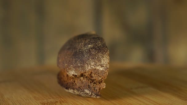 Frisches Stück Brot rotiert auf Holzschneidebrett — Stockvideo