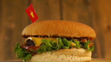 Üstünde küçük Vietnam bayrağı ve kürdanlı lezzetli bir hamburger. Lezzetli hamburger dönüyor..