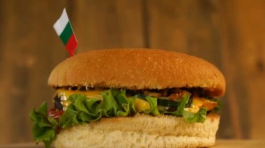 Üstünde küçük Bulgar bayrağı olan leziz bir hamburger ve kürdan. Lezzetli hamburger dönüyor..