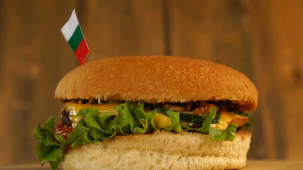 Deliciosa hamburguesa con pequeña bandera búlgara encima de ellos con palillos de dientes. Deliciosa hamburguesa giratoria. — Vídeo de stock