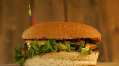 Üstünde kürdanla küçük Venezuela bayrağı olan lezzetli bir burger. Lezzetli hamburger dönüyor..