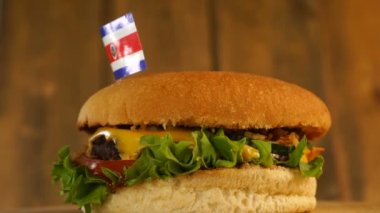 Üstünde küçük Kosta Rika bayrağı olan leziz bir burger ve kürdan. Lezzetli hamburger dönüyor..