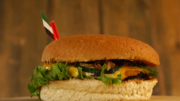 Délicieux hamburger avec petit drapeau des Émirats arabes unis sur le dessus avec cure-dents. Hamburger délicieux tournant. — Video