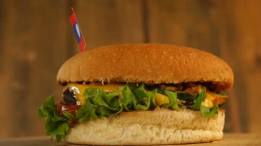 Üstünde küçük Laos bayrağı ve kürdanlı lezzetli bir burger. Lezzetli hamburger dönüyor..