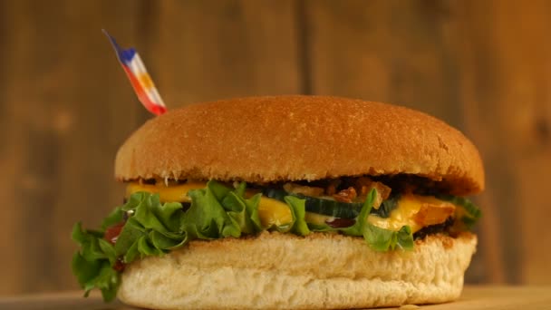 美味的汉堡包，上面挂着菲律宾小国旗和牙签。美味汉堡包旋转. — 图库视频影像