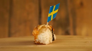 Balık, pirinç, yosun ve üzerinde İsveç 'in küçük bayrağı olan suşi tahta bir döner döner..