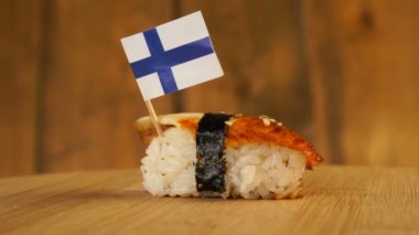 Balık, pirinç, deniz yosunu ve üzerinde Finlandiya 'nın küçük bayrağı bulunan suşi tahta bir döner tablada döner..