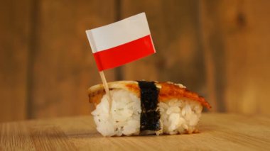 Balık, pirinç, deniz yosunu ve üzerinde Polonya bayrağı olan suşi tahta bir döner döner..