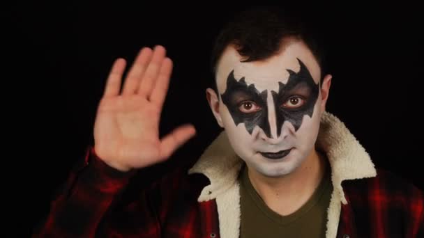 Man in demon makeup waving hand gesturing hello or goodbye on black background — Stock Video