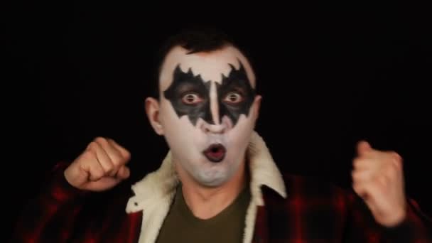 Дивовижні виграшні емоції смішної враженої кричущої людини в демонічному макіяжі на чорному тлі — стокове відео