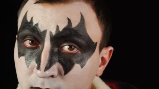 Wer beobachtet dich? Mann in Dämonen-Make-up bekommt Gesicht aus nächster Nähe, um in Kameralinse zu schauen — Stockvideo