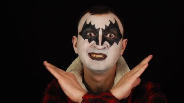 Mężczyzna w demonicznym makijażu zabrania czegoś przez skrzyżowanie rąk — Wideo stockowe