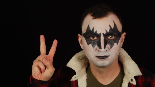 Mann in Dämonen-Make-up, das von 0 bis 5 auf schwarzem Hintergrund zählt — Stockvideo
