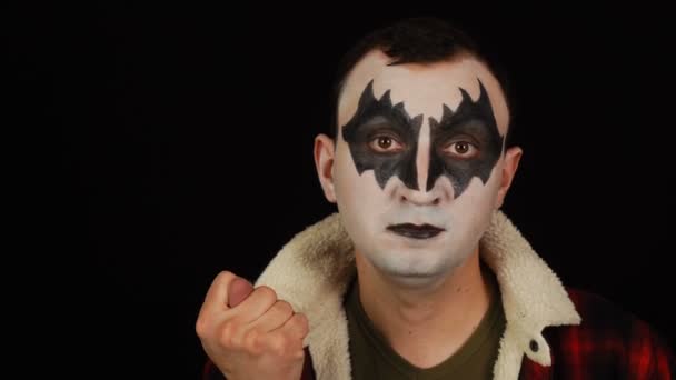 Man i demon makeup visar fikongest på svart bakgrund — Stockvideo