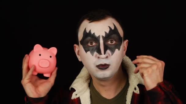 Man i skrämmande mask sätta ett mynt i spargris och spara pengar för halloween — Stockvideo