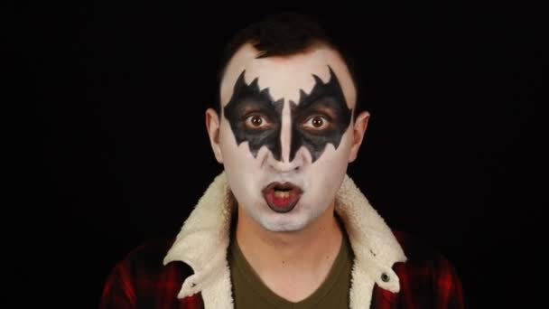 Людина в демоні макіяж розмовляє для камери на чорному тлі — стокове відео