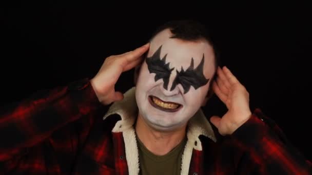 Man in demon make-up met hoofdpijn op zwarte achtergrond — Stockvideo