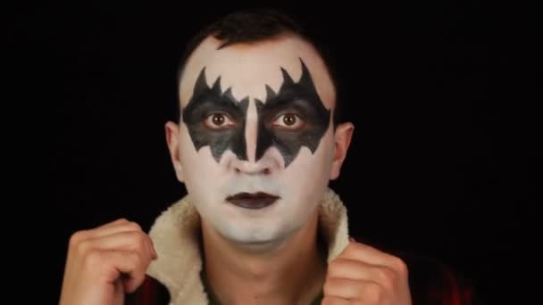 Een man die demonenmake-up op z 'n gezicht smeert. Halloween eindigt — Stockvideo