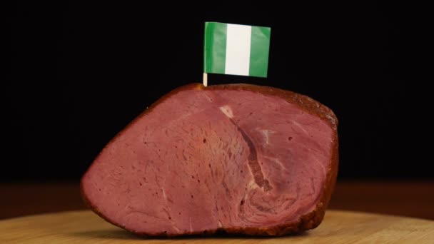 Personne plaçant des cure-dents drapeau nigérian décoratifs en morceaux de viande rouge. — Video