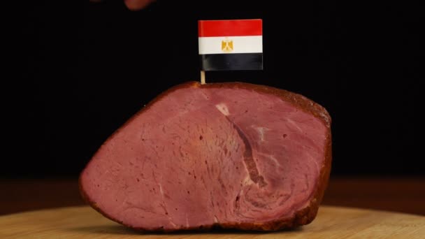 Person platziert Zahnstocher mit ägyptischer Flagge in Stück rotes Fleisch. — Stockvideo