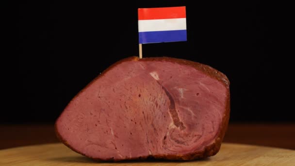 Pessoa que coloca palitos de dentes decorativos da bandeira holandesa em pedaços de carne vermelha. — Vídeo de Stock