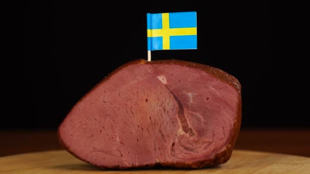 Πρόσωπο που τοποθετεί διακοσμητικές οδοντογλυφίδες σουηδικής σημαίας σε κομμάτι κόκκινου κρέατος. — Αρχείο Βίντεο