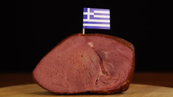 Person platziert Zahnstocher mit griechischer Flagge in Stück rotes Fleisch. — Stockvideo