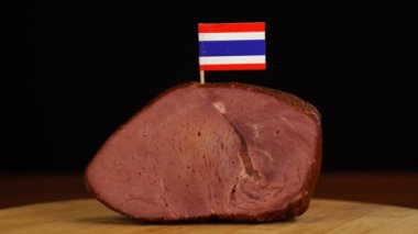 Dekoratif Tayland bayrağı kürdanlarını kırmızı et parçasına yerleştiren kişi.