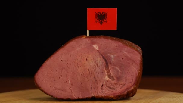 Person platziert Zahnstocher mit albanischer Flagge in Stück rotes Fleisch. — Stockvideo