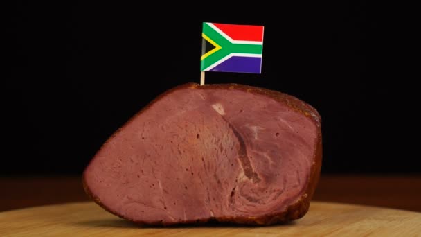 Pessoa que coloca palitos de dentes decorativos da bandeira sul-africana em pedaços de carne vermelha. — Vídeo de Stock