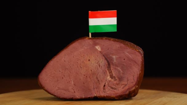 Persoon die decoratieve Hongaarse vlaggentandenstokers in stuk rood vlees plaatst. — Stockvideo